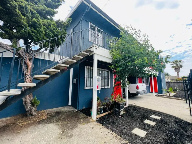 a view of small space with large trees and wooden fence