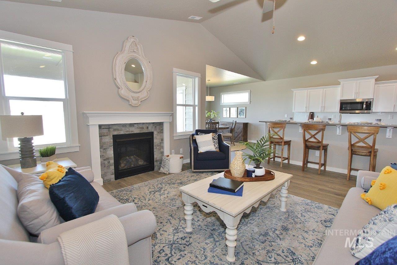 3553 North Eleanor Way Star, ID 83669 - Photo 7 of 20 Living room with lofted ceiling, wood finished floors, a stone fireplace, a ceiling fan, and recessed lighting