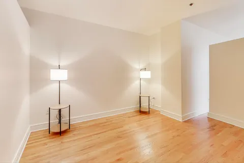a view of a room with wooden floor a table and a mirror
