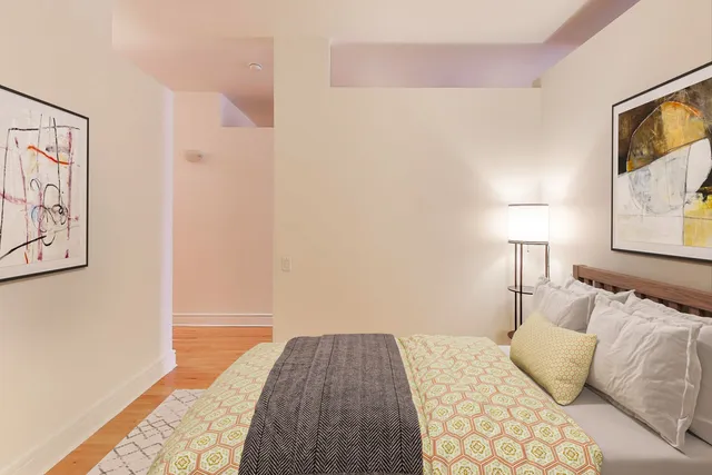 a bedroom with a bed and painting on the wall