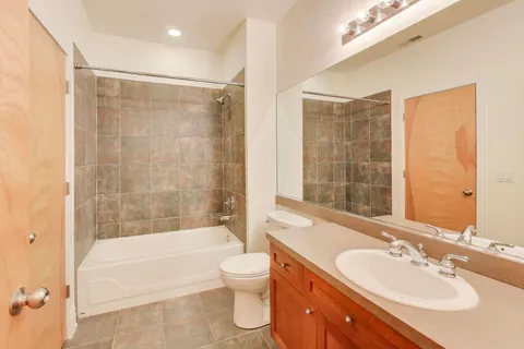 a bathroom with a bathtub shower sink mirror and toilet