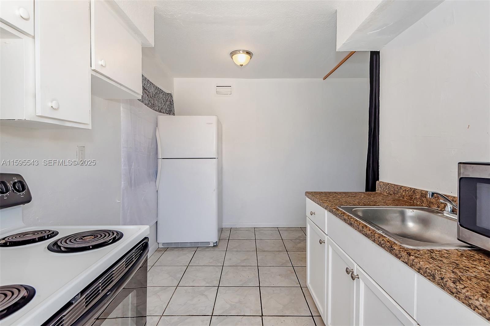 5600 Northwest 7th Court, Unit 14 Miami, FL 33127 - Photo 3 of 8 a kitchen with a sink stove and refrigerator
