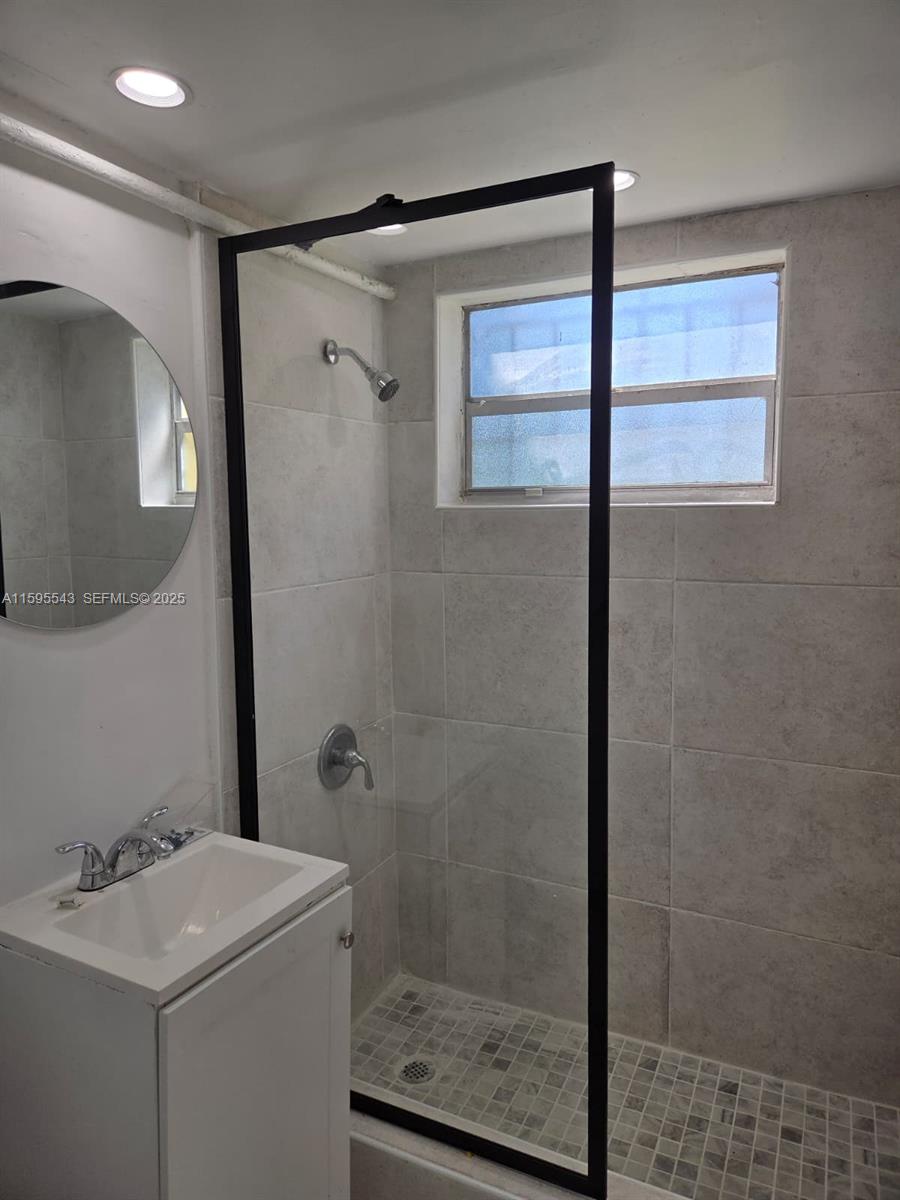 5600 Northwest 7th Court, Unit 14 Miami, FL 33127 - Photo 4 of 8 a bathroom with a shower sink and mirror
