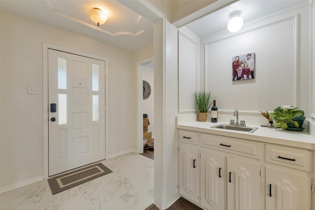 705 South Grove Road Richardson, TX 75081 - Photo 4 of 26 Entryway featuring a decorative front door with frosted glass panels, an overhead light fixture, and marble-look tile flooring