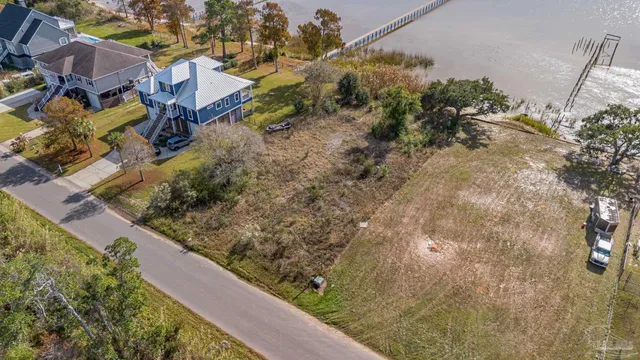 an aerial view of a house with a yard and lake view