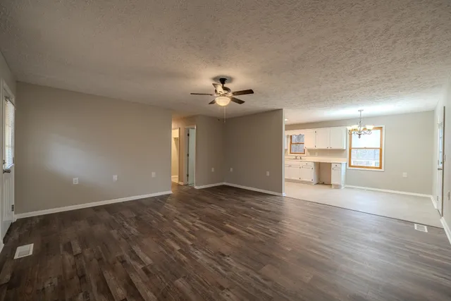 a view of a livingroom with wooden floor and a ceiling fan