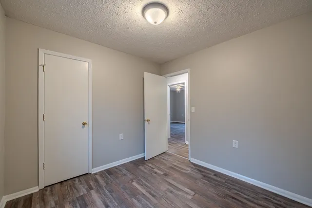 a view of a room with wooden floor closet and windows