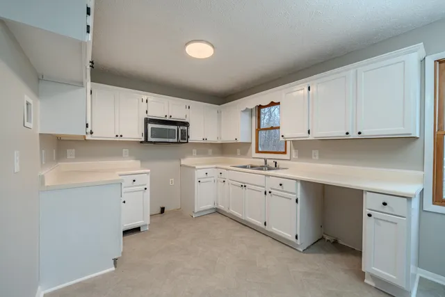 a kitchen with cabinets appliances a sink and a counter top