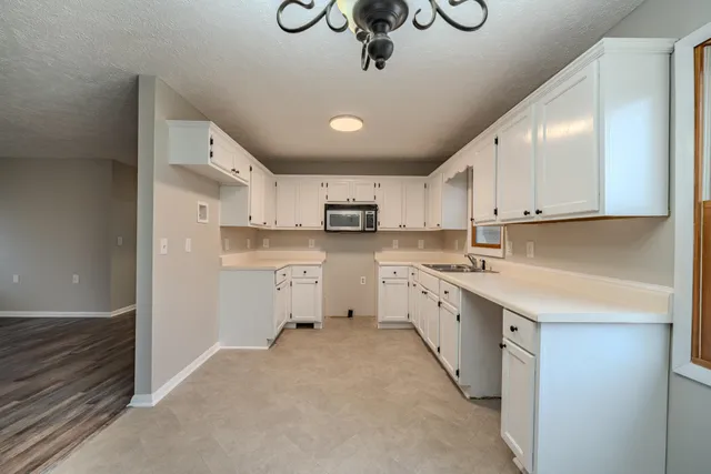 a large kitchen with stainless steel appliances lots of white cabinets