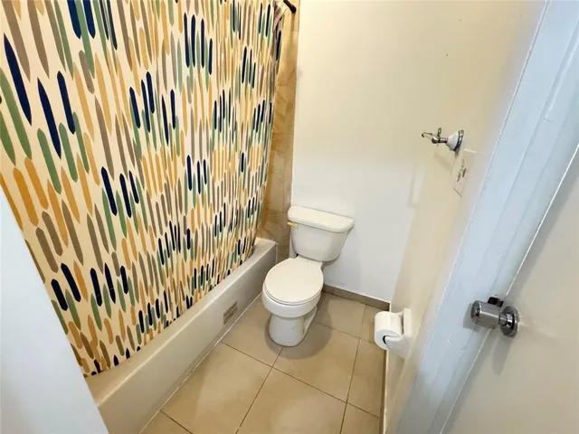 a bathroom with a toilet and a shower curtain