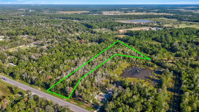 an aerial view of a houses with a yard