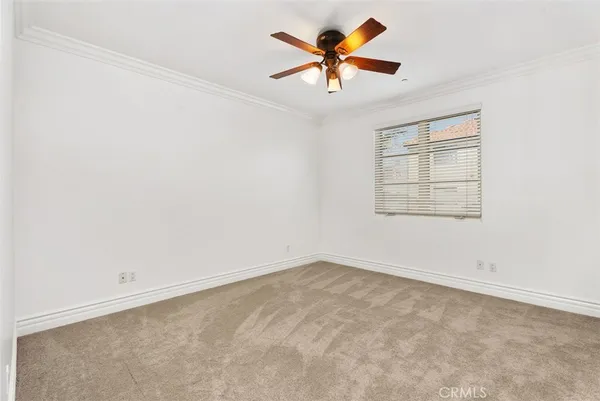 an empty room with a window and a fan
