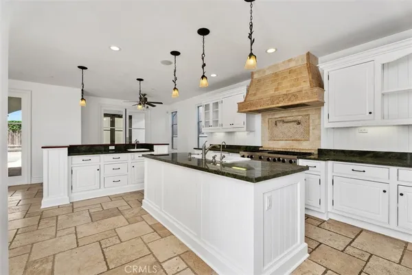 a kitchen with stainless steel appliances granite countertop a stove a sink and a refrigerator