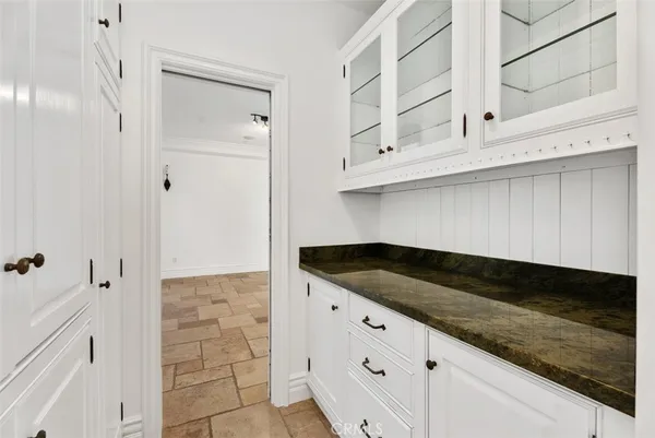 a kitchen with granite countertop white cabinets and a sink