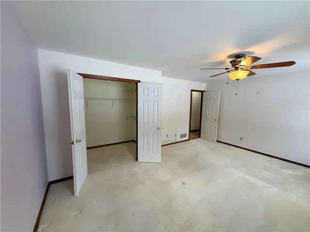 an empty room with closet and fan