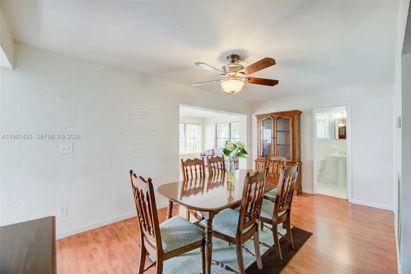a view of a dining room with furniture a chandelier and wooden floor