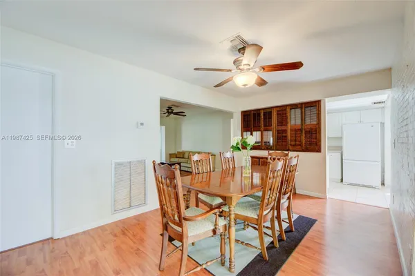 a view of a dining room with furniture and a chandelier fan