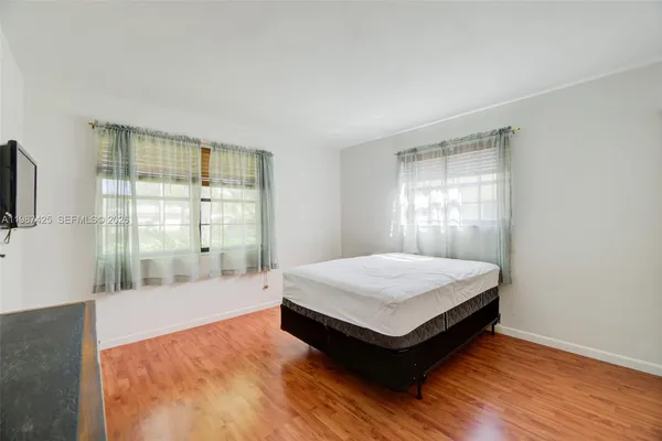 a spacious bedroom with a bed and a flat screen tv