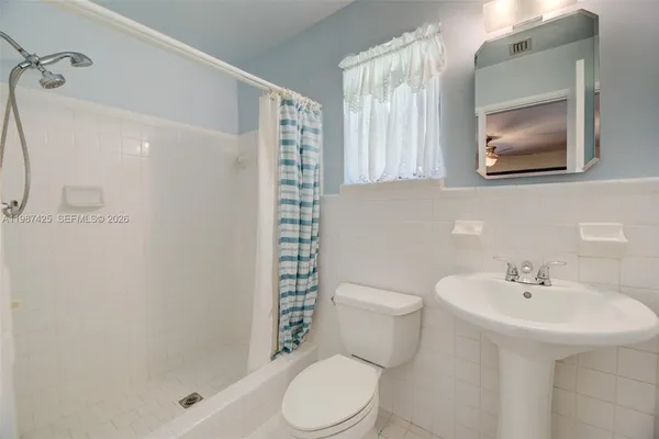 a white toilet sitting next to a bathroom sink