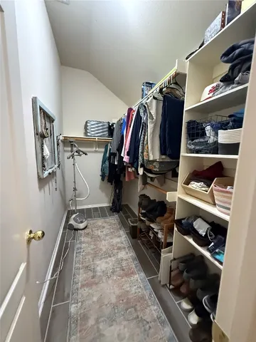 a view of walk in closet with clothes and shoes