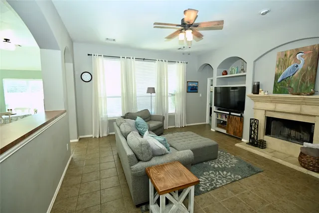 a living room with furniture a fireplace and a flat screen tv