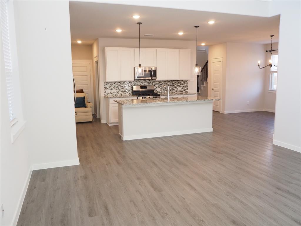 2502 Sun Grove Road Melissa, TX 75454 - Photo 13 of 40 a view of kitchen with kitchen island wooden floor center island and stainless steel appliances