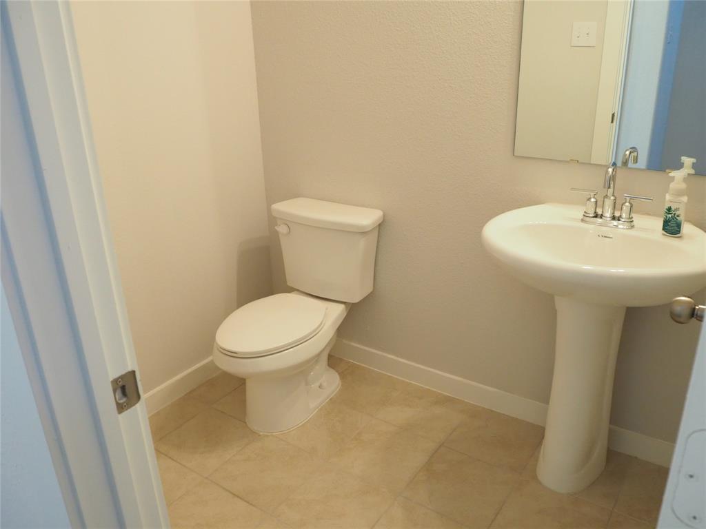2502 Sun Grove Road Melissa, TX 75454 - Photo 20 of 40 a bathroom with a sink a toilet and a mirror