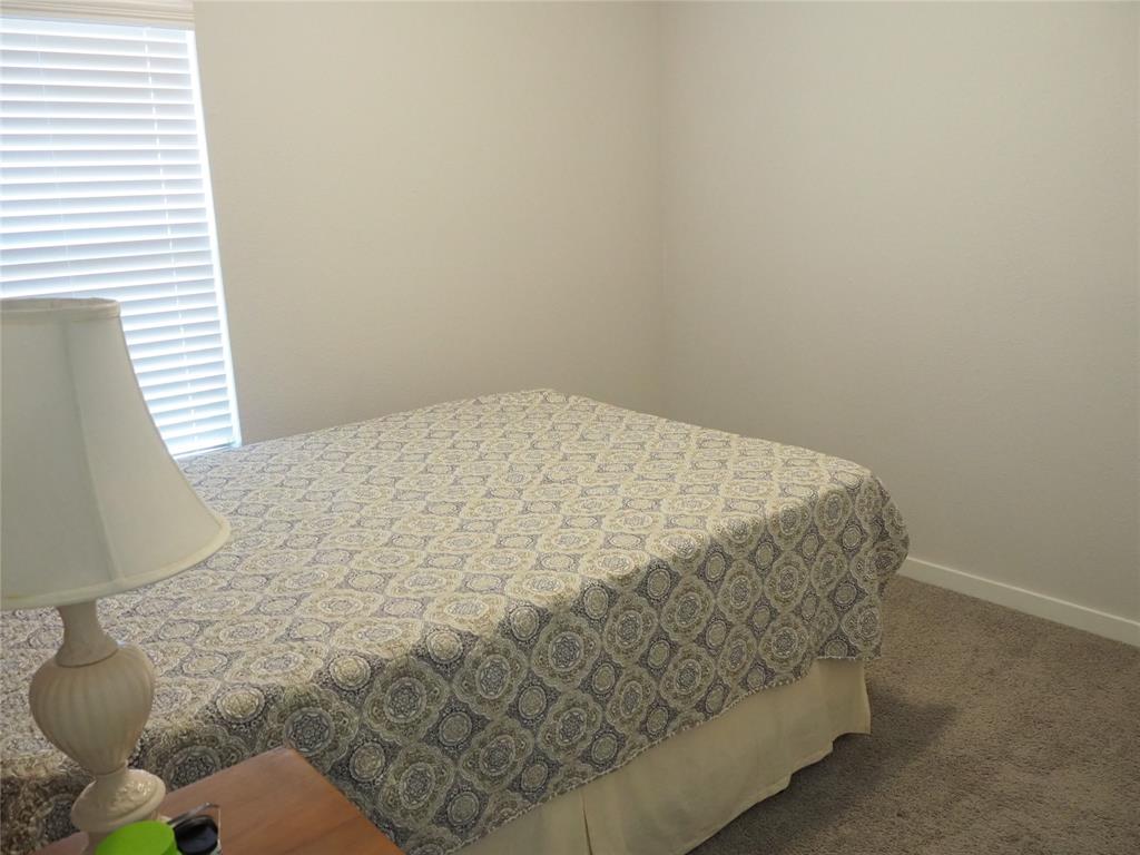 2502 Sun Grove Road Melissa, TX 75454 - Photo 29 of 40 a bed sitting in a bedroom next to a window