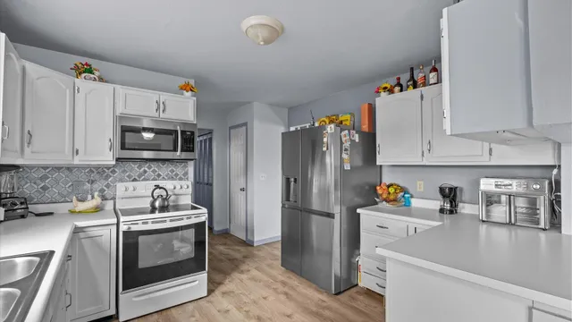 a kitchen with stainless steel appliances granite countertop a refrigerator sink and microwave