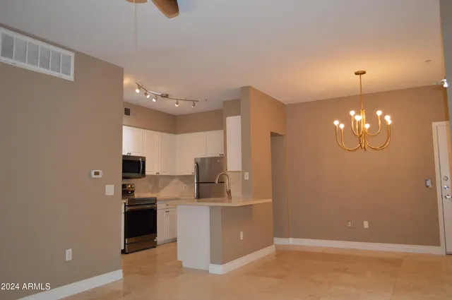 a kitchen with kitchen island a counter top space a sink stainless steel appliances and cabinets