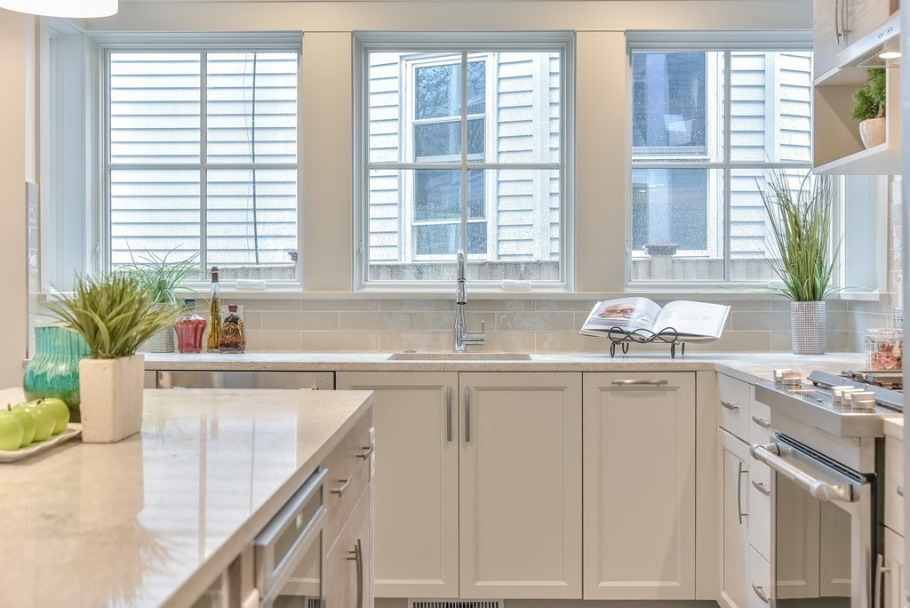 34 Rossmore Road, Unit ONE Boston, MA 02130 - Photo 3 of 21 a kitchen with granite countertop a sink and white cabinets