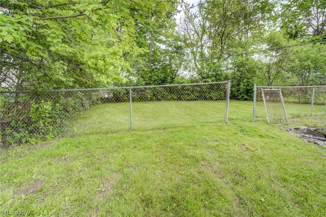 4383 Wyatt Road Cleveland, OH 44128 - Photo 24 of 33 Expansive grassy yard featuring perimeter chain-link fencing and mature trees