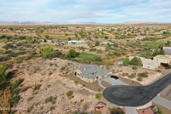 an aerial view of a house with a yard and lake view in back
