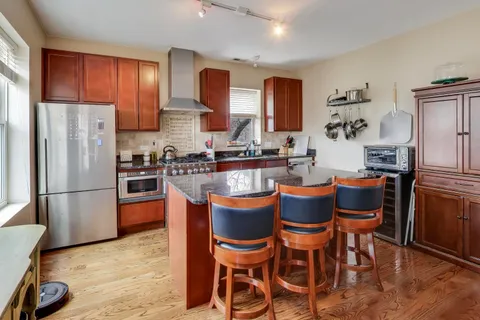 a kitchen with granite countertop appliances a sink and a refrigerator