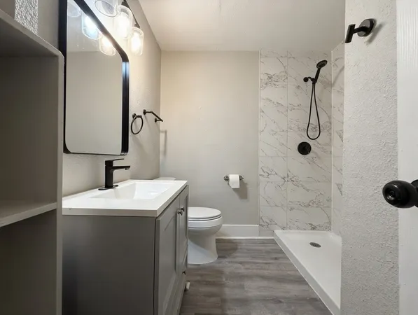 a bathroom with a toilet sink and shower