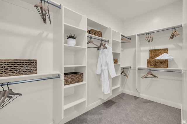4016 South Burch Way Ogden, UT 84405 - Photo 14 of 30 Walk-in closet featuring built-in shelving, multiple hanging rods, white cabinetry, neutral wall color, and grey carpet flooring