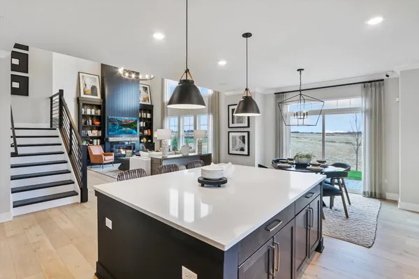 a kitchen with sink a refrigerator and chairs