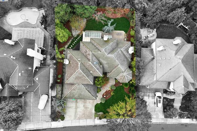 an aerial view of a house with a yard and large trees