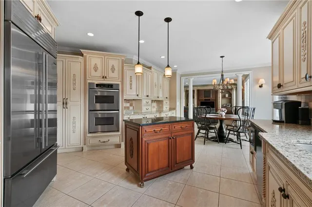 a kitchen with stainless steel appliances granite countertop a refrigerator a oven and a sink