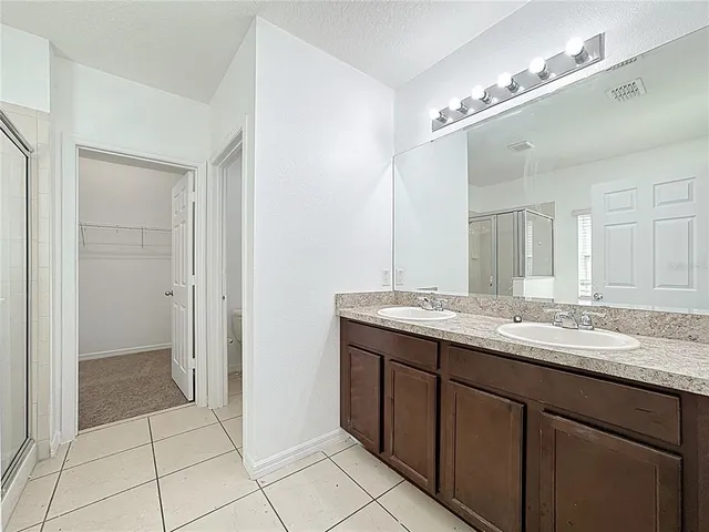 a bathroom with a granite countertop sink a mirror and a shower