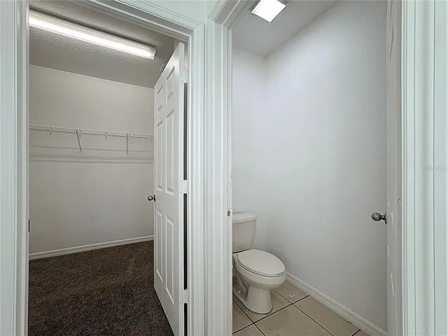 a bathroom with a granite countertop toilet and a sink