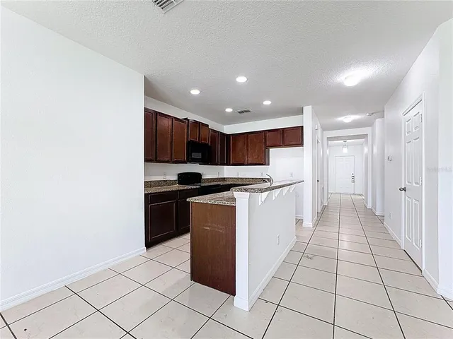 a kitchen with stainless steel appliances granite countertop a refrigerator and a stove