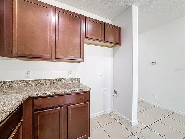 a kitchen with granite countertop cabinets and refrigerator