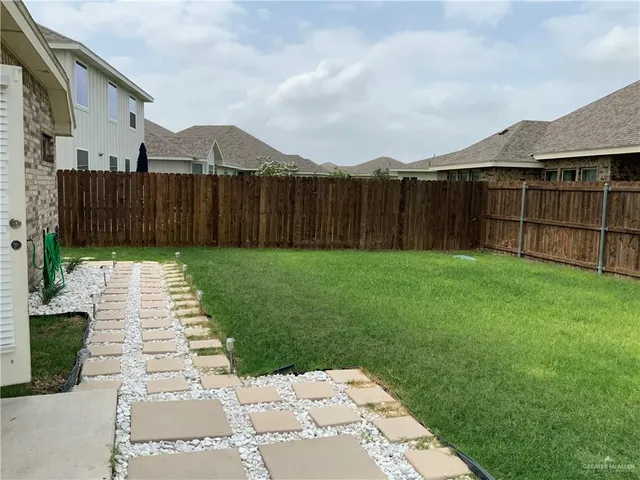 a view of a backyard with wooden fence