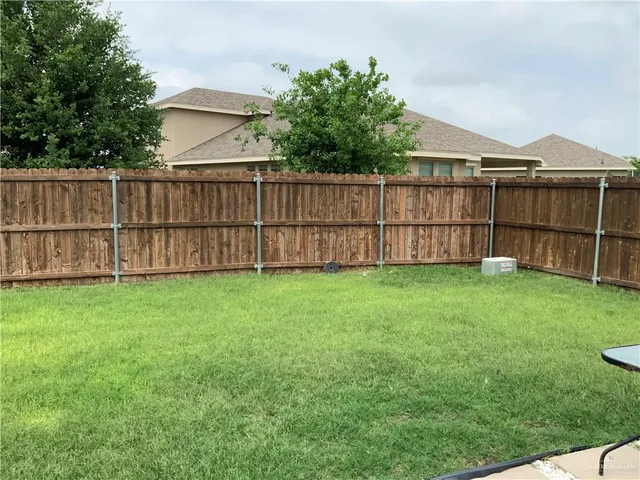 a view of a backyard with wooden fence