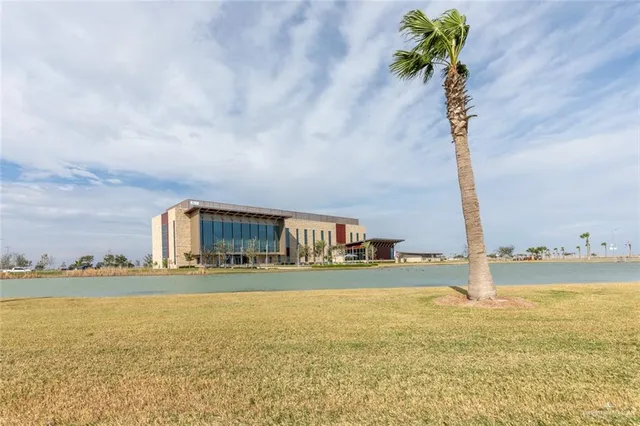a front view of house with yard and ocean