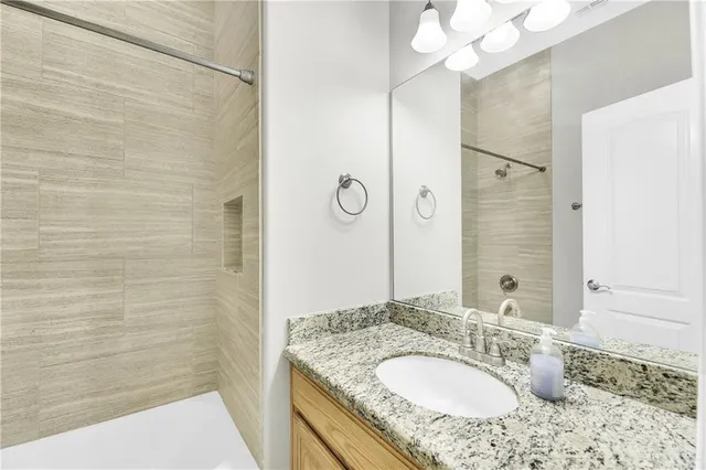a bathroom with a granite countertop sink and a mirror