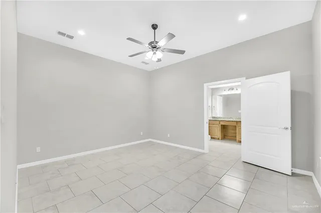 an empty room with a ceiling fan and a bathroom