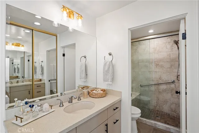 a bathroom with a shower sink vanity and mirror