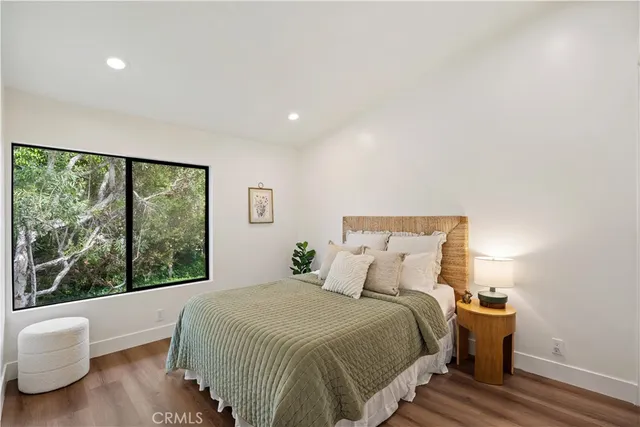 a bedroom with a large bed and wooden floor